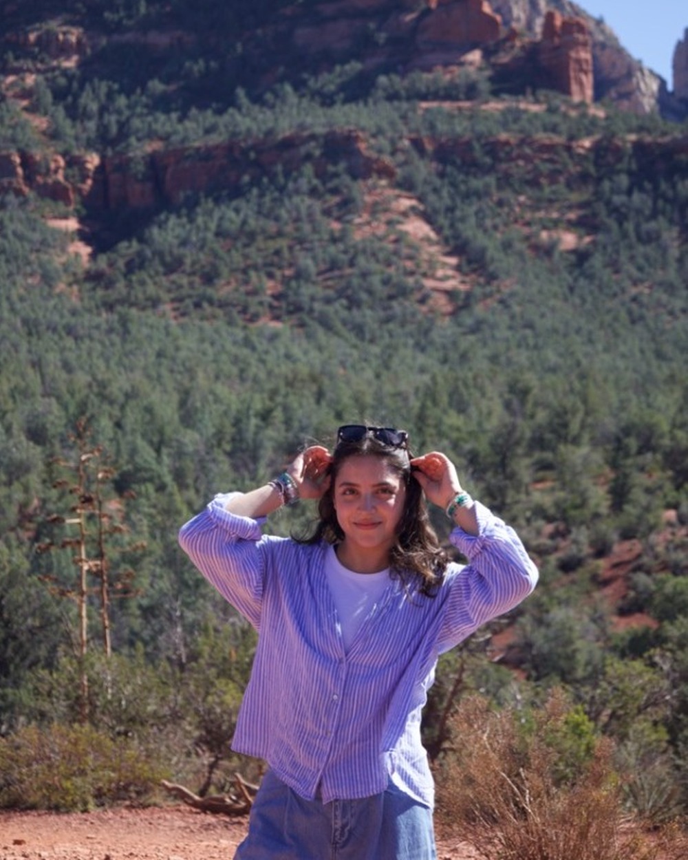 Fernanda Padilla smiling at the camera with red rock mountains behind her