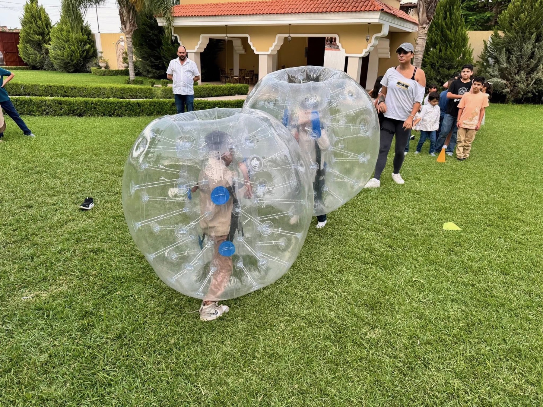 Kids playing in bumper balls at a family lawn party