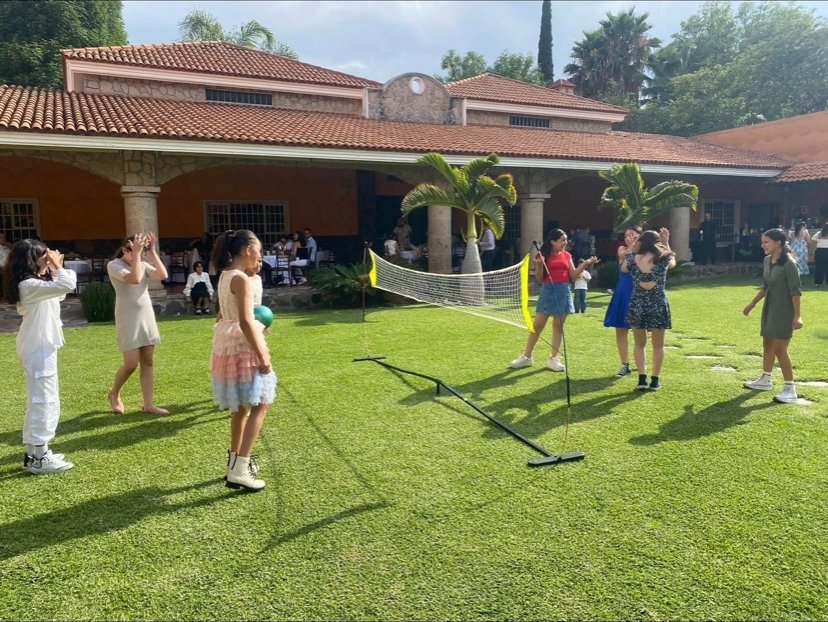Kids playing lawn games while guests dine on the veranda at a private Grazie Mille party