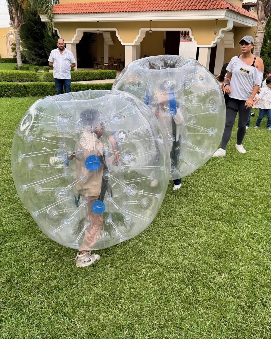 Kids playing in bumper balls at a family lawn party